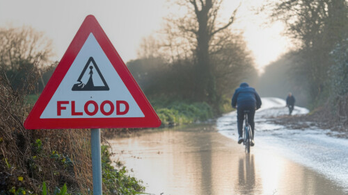 cyclist passing flooded road