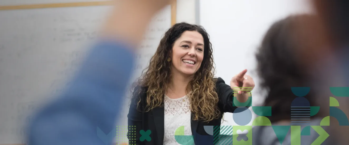 teacher in classroom selecting a student to answer a question