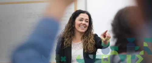 teacher in classroom selecting a student to answer a question