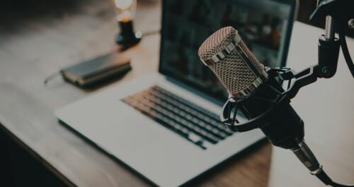 close-up of microphone and laptop at desk