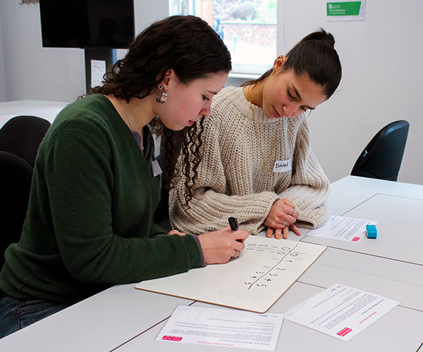 Two female students solving a maths problem